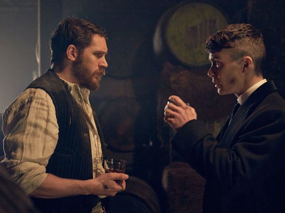 An image of Thomas Shelby and Alfie Solomons (From Peaky Blinders) standing facing each other in a dark cellar