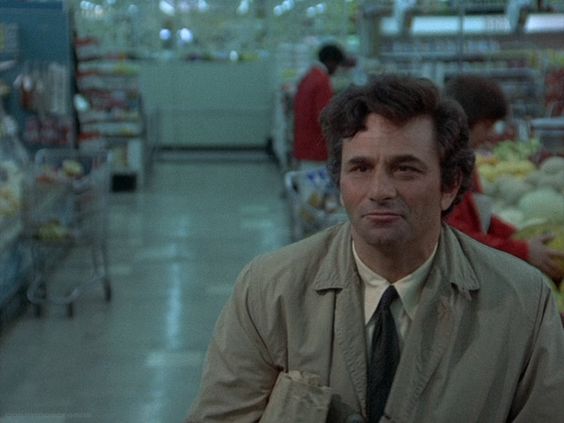 An screenshot of the show Columbo, as Columbo looks at someone off camera in a blue supermarket