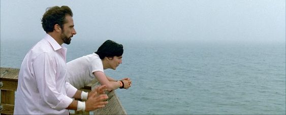 An screenshot of the movie Little Miss Sunshine, as two characters stand on a pier over the ocean