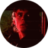 An image of an 80s man looking on in horror with dark red lighting